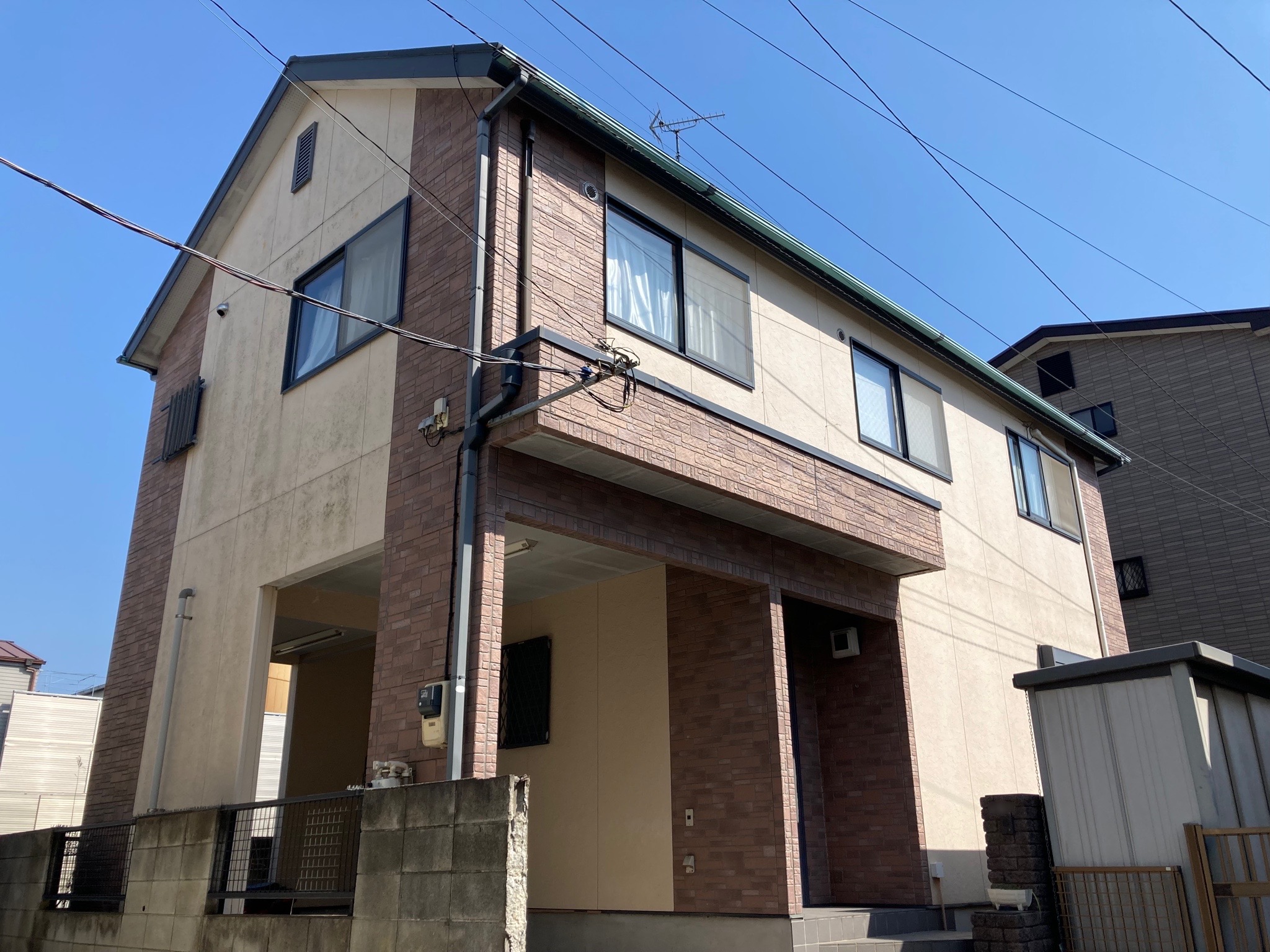 八潮市中馬場の塗り替え前の戸建て外観。クリーム色とレンガの二階建てでガレージもある