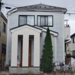 すっきりと白系の色で塗り替えられた外壁の戸建て住宅
