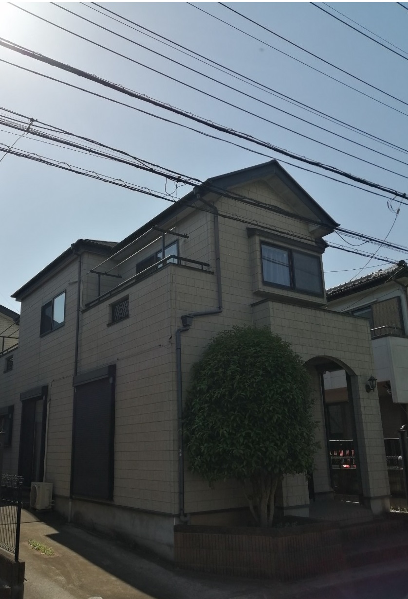 薄茶色のぼけた色の外壁をした戸建て住宅