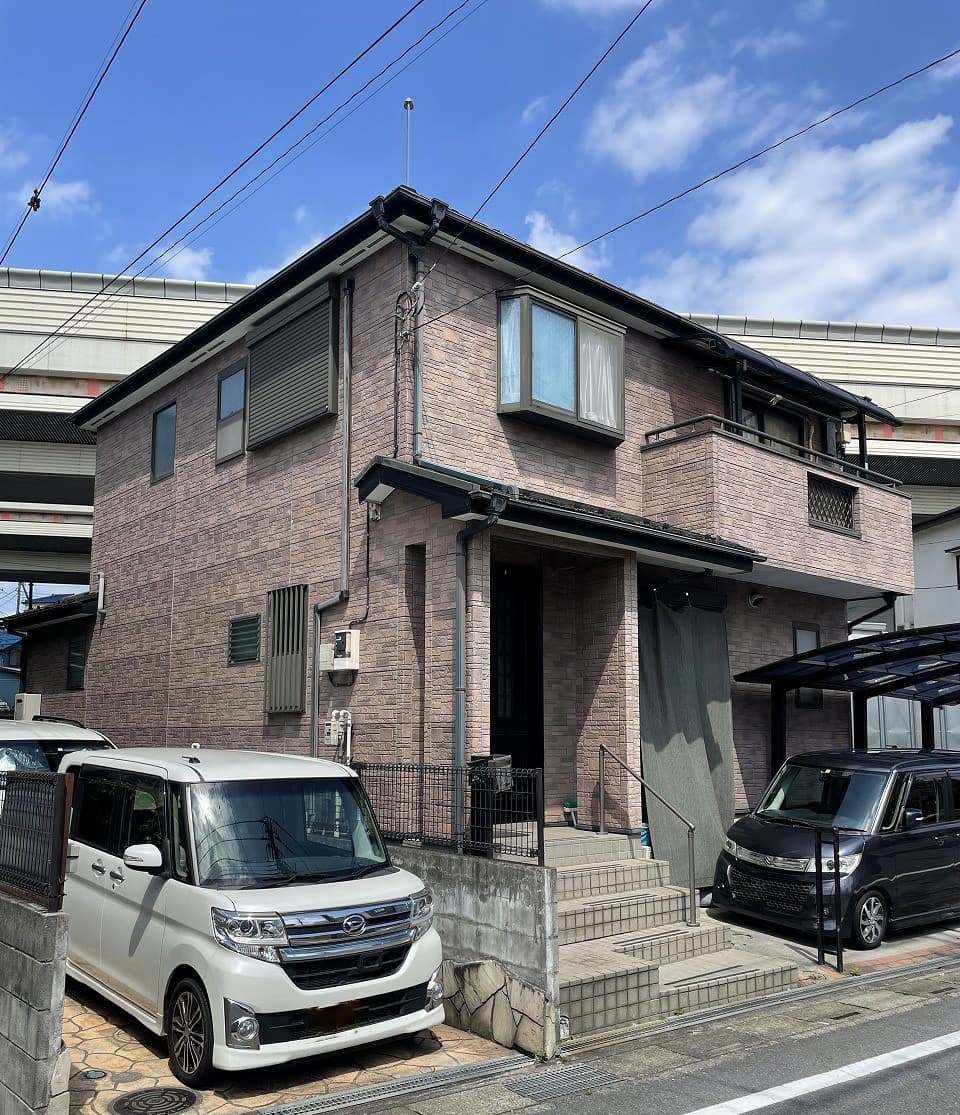 塗装前の日やけたサイディング壁の二階建て住宅