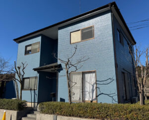 稲敷市江戸崎の青い家とその前にある木。外壁塗装後の新しい印象を伝えています