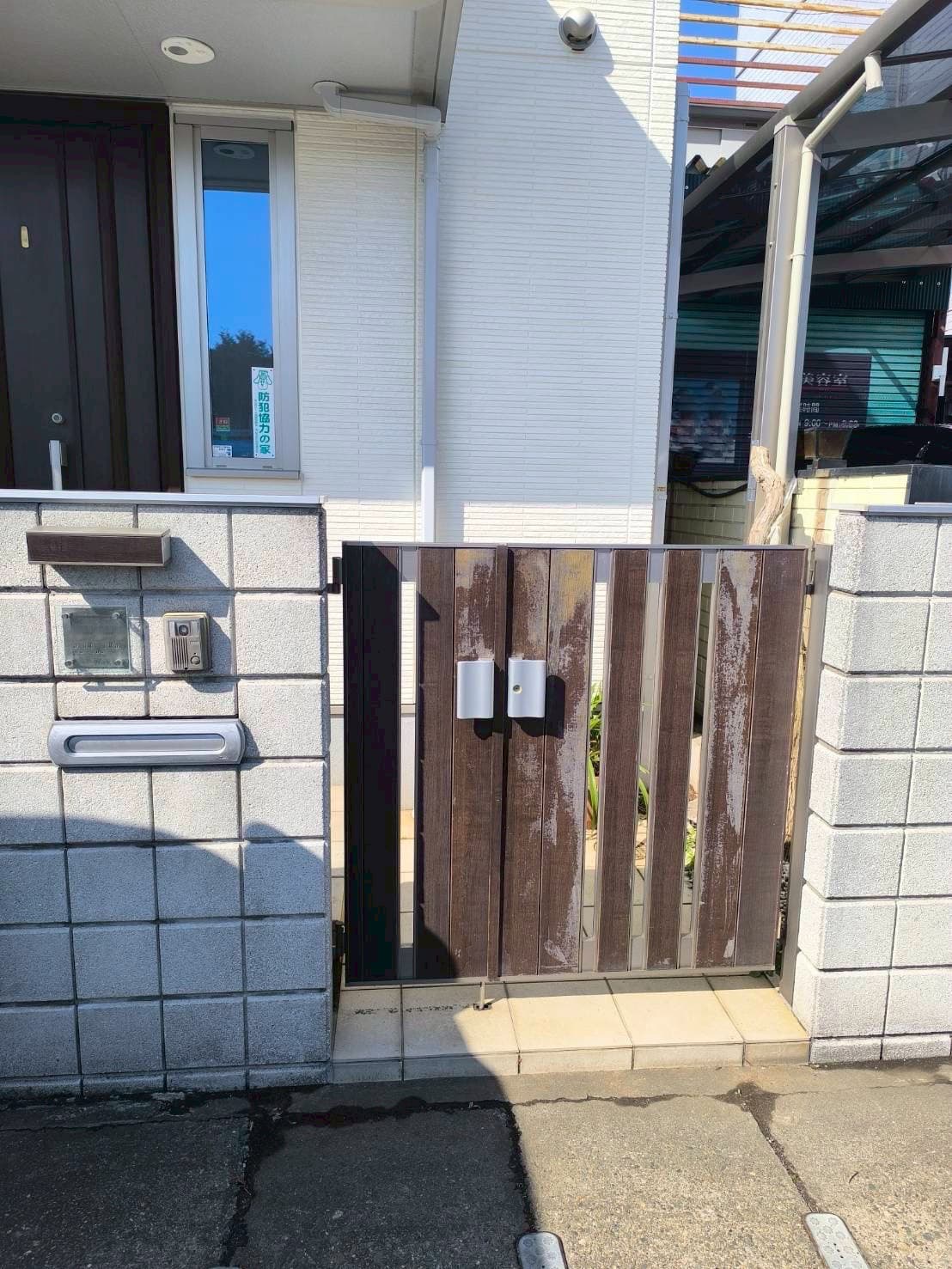 建物の横に開いている門扉の写真。流山市野々下での交換前の様子