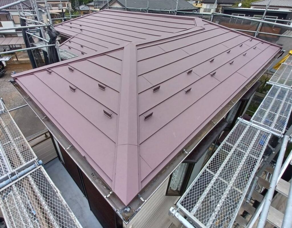 屋根上葺き工事の施工後の写真　ワインレッドの屋根