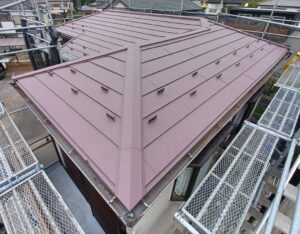 屋根上葺き工事の施工後の写真　ワインレッドの屋根