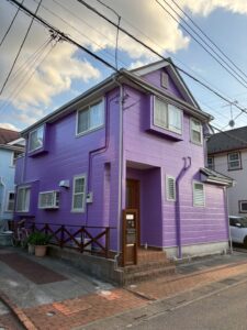 外壁塗装工事の施工前の写真　濃いピンク紫の外壁の家