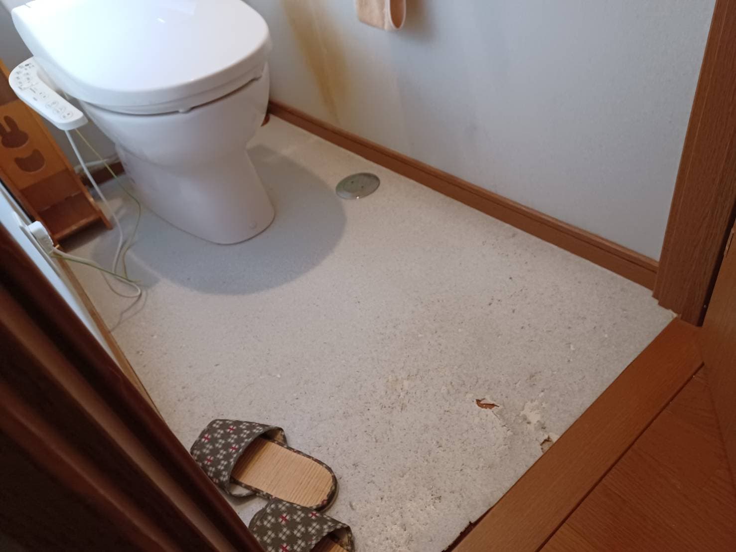 白いトイレの画像　フローリングがはがれている