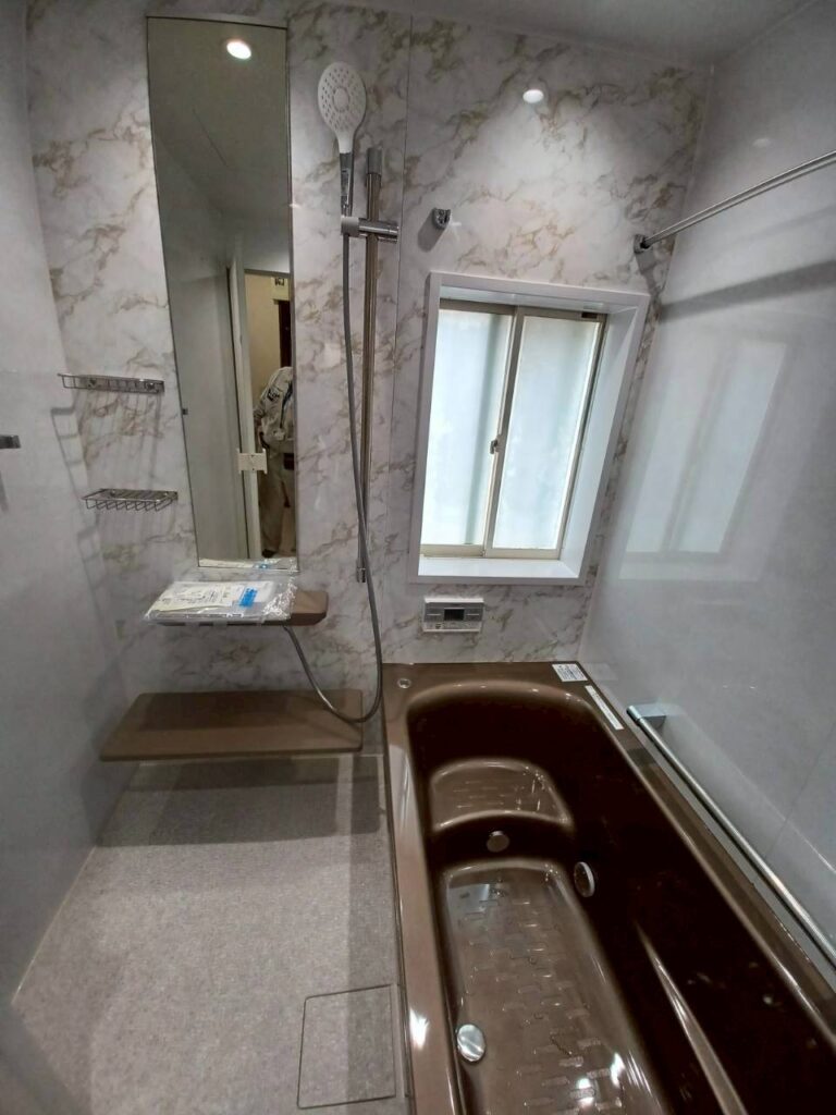 浴室改修施工後の写真　右側に茶色の浴槽左側に縦長い鏡がついている