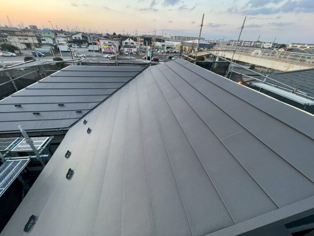 屋根上葺き工事の施工後の写真屋根の上から撮った写真艶のあるチャコールの屋根