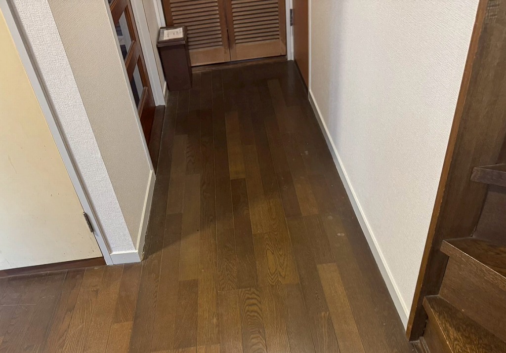 柏市あけぼのの廊下、木製の床が傷んでいる施工前の状態