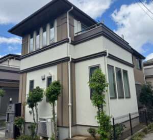 柏市豊四季の家、外壁塗装後の美しい仕上がりと小さな庭が見える